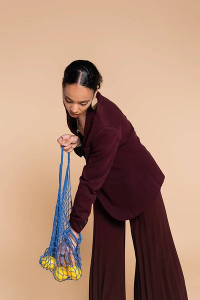 Stylish African American Woman Burgundy Suit Holding Net Bag Lemons — Stock Photo, Image
