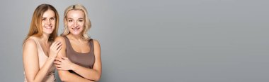 Smiling women with freckles and acne on skin standing on grey background, banner  clipart