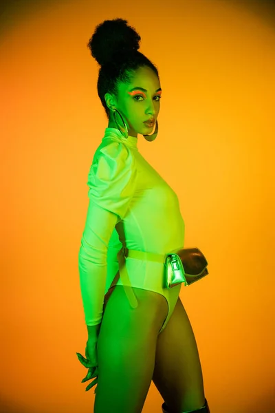 Stylish African American Model Neon Visage Bodysuit Standing Orange Background — Stock Photo, Image