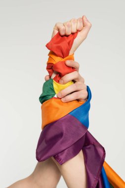 partial view of hands of nonbinary couple with lgbt flag isolated on grey clipart