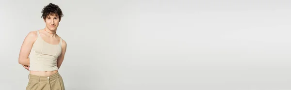 Brunetka Pansexual Model Zbiornik Top Pozowanie Ręce Plecami Odizolowany Szary — Zdjęcie stockowe