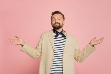 İyi giyimli bir Fransız ceket ve boyun atkısı giymiş pembe bir omuz silkme hareketi sergiliyor. 