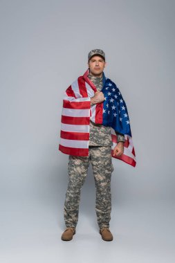 Anma gününde Amerika Birleşik Devletleri bayrağına sarılmış, kamuflaj üniformalı vatansever asker. 