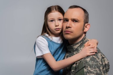 patriotic kid hugging military man in uniform and crying during memorial day isolated on grey clipart