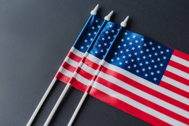 top view of American flags with stars and stripes for memorial day isolated on black  clipart