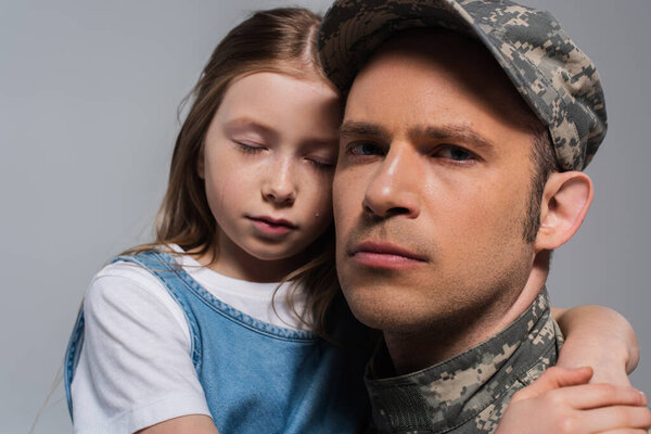грустная девушка обнимает отца в военной форме и плачет в день памяти, изолированный от серых