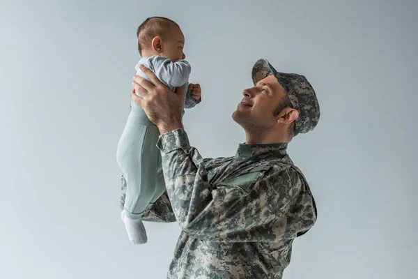 Щасливий Солдат Уніформі Тримає Хлопчика Руках Ізольовано Сірому — стокове фото