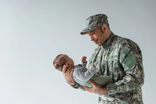 Feliz Soldado Uniforme Mirando Niño Recién Nacido Sonriendo Aislado Gris —  Fotos de Stock
