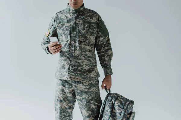 Vista Cortada Americano Serviceman Usando Smartphone Enquanto Segurando Mochila Isolada — Fotografia de Stock