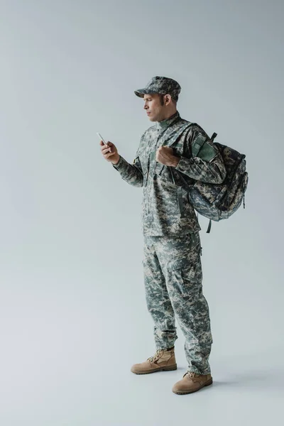 Military Man Cap Army Uniform Standing Backpack Holding Smartphone Grey — Stock Photo, Image