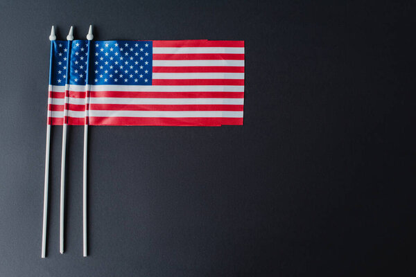 flat lay of American flags with stars and stripes for memorial day isolated on black 