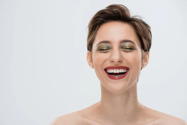 Pozytywna Młoda Kobieta Błyszczącym Makijażem Krótkimi Włosami Uśmiechnięta Szaro — Zdjęcie stockowe