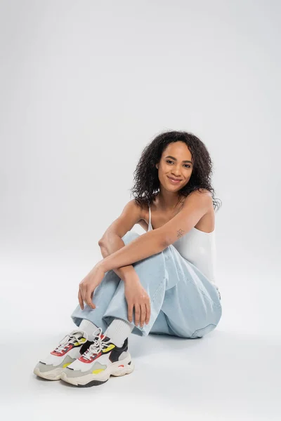 Full Length African American Woman Blue Jeans Sneakers Sitting Smiling — Stock Photo, Image