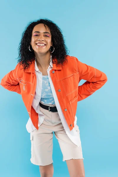 Şık Turuncu Ceketli Mavi Renkli Kameraya Gülümseyen Afro Amerikan Kadın — Stok fotoğraf