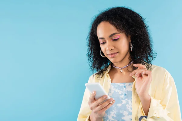 Stylowa Afroamerykanka Obręczy Kolczyki Koraliki Pomocą Telefonu Komórkowego Odizolowany Niebiesko — Zdjęcie stockowe