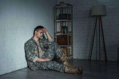 Frustrated military man with ptsd sitting on floor after homecoming  clipart