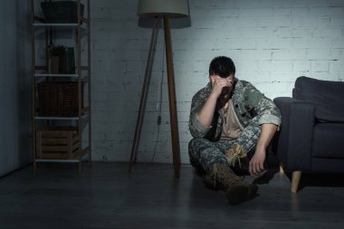 Gece evde depresyon geçiren askeri üniformalı asker. 