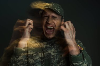 Double exposure of anxious soldier in camouflage uniform screaming while suffering from ptsd isolated on dark grey  clipart