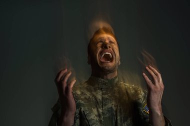 Double exposure of serviceman screaming while suffering from dissociation disorder isolated on dark grey  clipart