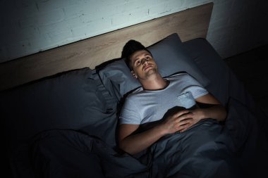 Travma sonrası stres bozukluğu olan ve geceleri uykusuzluk çeken genç bir adam. 
