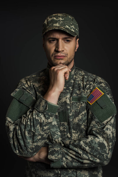 American soldier in camouflage uniform and cap suffering from ptsd isolated on black 