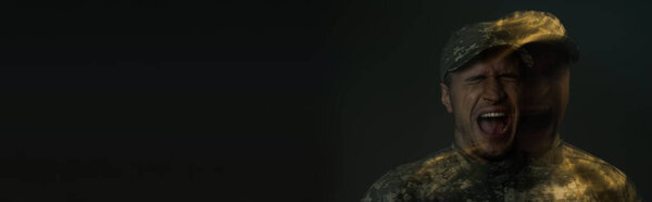 Double exposure of soldier in camouflage uniform screaming while suffering from ptsd isolated on dark grey, banner 