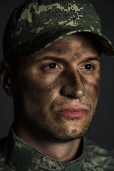 close up of with dirt on face suffering from ptsd isolated on grey 