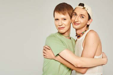 Igbt 'nin mutlu arkadaşları birbirlerine sarılıp destek olurken stüdyodaki gri arka planda, Haziran' daki lgbtq halk tatilinde, onur günü konseptinde beraberce gurur duyuyorlar. 