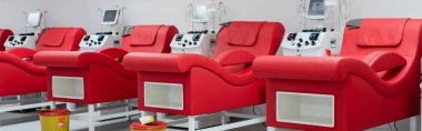 row of comfortable medical chairs with ergonomic design, trash buckets and automated transfusion machines with monitors in modern blood donation center, banner clipart
