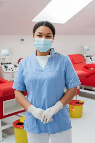 Enfermera Multirracial Uniforme Azul Máscara Médica Guantes Látex Mirando Cámara —  Fotos de Stock