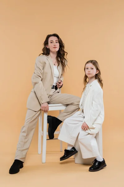 穿着西服的公司妈妈和女儿 坐在高高的椅子上 用米色背景 时髦服装 正式服装 公司妈妈 母亲和事业等近视镜头的女人 — 图库照片