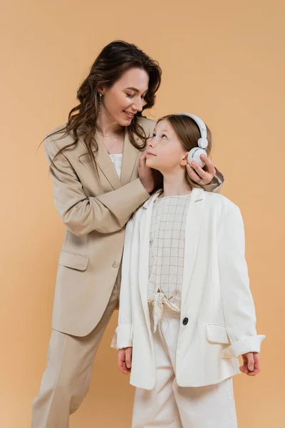 Mother Daughter Suits Happy Woman Wearing Wireless Headphones Girl While — Stock Photo, Image