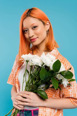 sensuality, cheerful asian woman with red hair holding white flowers on blue background, casual attire, generation z, floral bouquet, spring vibes, happy face, generation z, youth culture  clipart