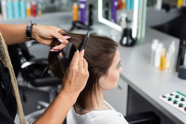 salon job, beauty worker brushing and clipping hair of woman, professional hair clip, comb, hairstyling, hair treatment, hairdo, extension, salon customer, beauty profession, high angle view  clipart