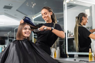 Güzellik salonu, yuvarlak fırçalı profesyonel güzellik işçisi ve saç kurutma makinesi mutlu müşteri saçı, kısa saçlı esmer kadın, kuaför, müşteri memnuniyeti, saç hacmi 