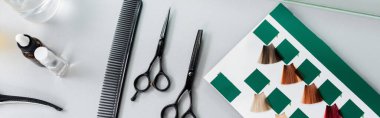 top view of hair cutting tools, hairdressing scissors, bottles, comb and hair palette book on white surface in beauty salon, hairdressing gear, beauty industry, hair fashion, banner  clipart