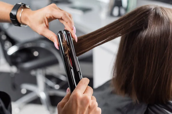 ヘアアイロン 女性の顧客のヘアスタイリングヘアとプロの美容師 美容労働者 クライアント満足度 短い髪を持つブルネットの女性 美容室 ヘアファッション トリミング — ストック写真
