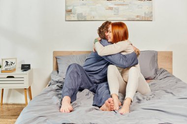quality time, day off without kids, redhead and happy husband and wife, bearded man and woman hugging each other, parents alone at home, modern lifestyle, relationship  clipart