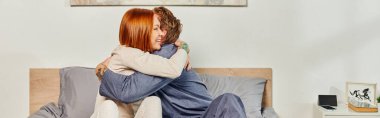 quality time, day off without kids, redhead husband and wife, bearded man and woman hugging each other, cheerful parents alone at home, modern lifestyle, relationship, banner  clipart