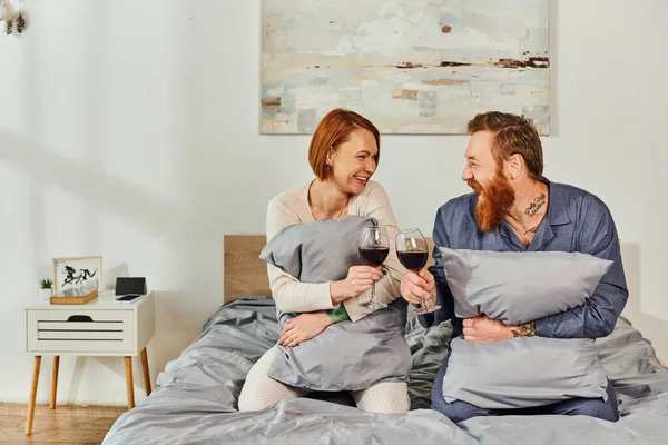 没有孩子的一天休息 纹身的人 拿着红酒的已婚夫妇 红头发的丈夫和妻子 享受时间 周末在一起 父母单独在家 — 图库照片