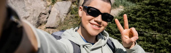 Wesoły Krótkowłosy Młoda Kobieta Podróżnik Okularach Przeciwsłonecznych Plecakiem Pokazując Gest — Zdjęcie stockowe