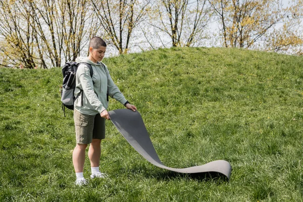 관광객을 배낭을 자연을 배경으로 풀밭에 매트를 설치하는 여름의 — 스톡 사진