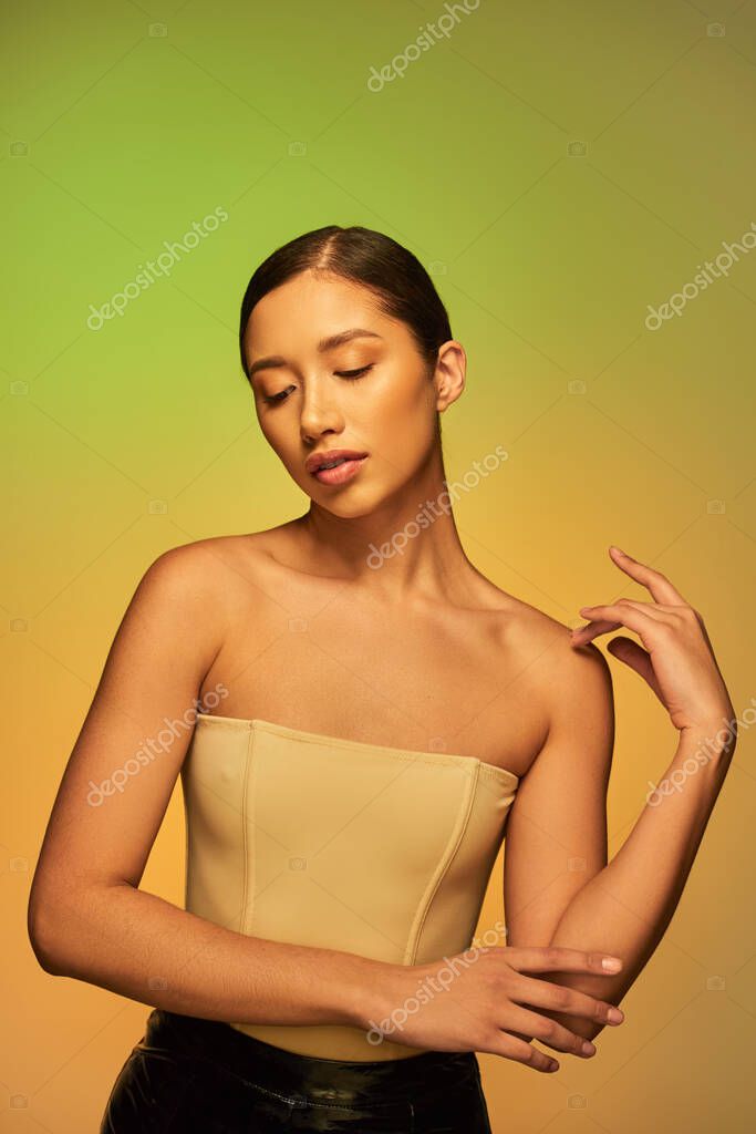 Beauty campaign, young asian woman with bare shoulders, beauty model posing on green background, gradient, glowing and youthful skin, natural beauty, skin perfection