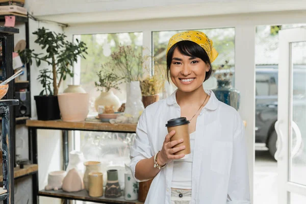 Positive Young Asian Artist Headscarf Workwear Looking Camera Holding Coffee — Stock Photo, Image