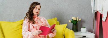 concept photography, woman with brunette wavy hair, domestic life, attractive housewife reading book, sitting on yellow couch, comfortable living, domestic lifestyle, banner clipart
