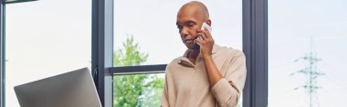 Kapsama, myasthenia gravis, ptosis sendromlu cesur Afro-Amerikan iş adamı akıllı telefonla konuşuyor ve monitöre bakıyor, pencerelerin yanındaki koyu tenli ofis çalışanı, afiş. 