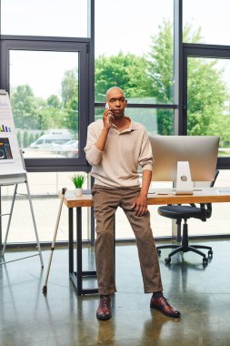 Myasthenia Gravis, gözü kara Afro-Amerikan iş adamı. Telefon görüşmesi yapıyor ve bastonla masanın yanında duruyor. Koyu tenli ofis çalışanı, dahil edilme, bilgisayar monitörü. 