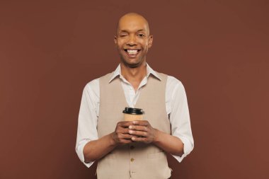 Kapsama, mutlu ve cesur miastenya gravis sendromu olan Afro-Amerikan erkeği, elinde kağıt bardakla, kahverengi arka planda kronik hastalığı olan koyu tenli adam, paket kahve. 