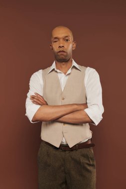 inclusion, myasthenia gravis syndrome, bold african american man standing with folded arms, looking at camera, dark skinned, real people, neurological disorder, physical impairment, serious  clipart