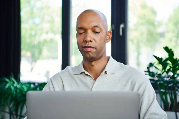 ptosis, eye syndrome, bold african american businessman looking at laptop, dark skinned office worker with myasthenia gravis disease, diversity and inclusion, professional headshots